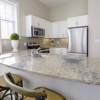 A modern kitchen with granite countertops and stainless steel appliances.