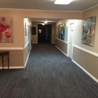 A view of a well-lit hallway adorned with colorful artwork.