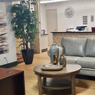 A cozy waiting area featuring modern furniture and decorative elements, perfect for an office environment.