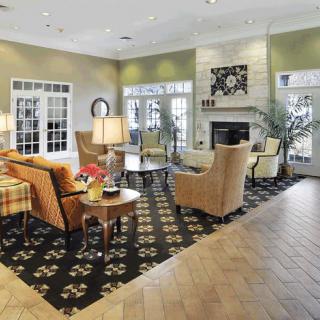 A well-decorated living room with armchairs, a fireplace, and elegant decor.