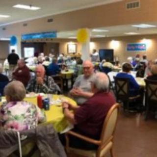 A group of seniors socializing at a community event indoors.