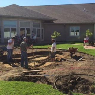 Workers engaged in a landscaping project in a backyard.