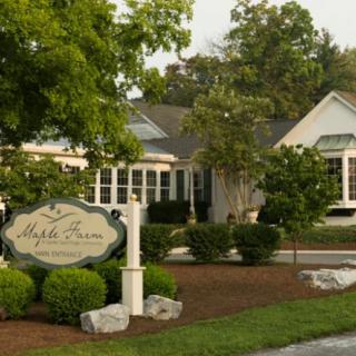 A charming restaurant with a welcoming outdoor landscape and a prominent sign.