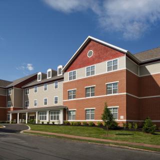 A modern brick residential building under a clear blue sky.