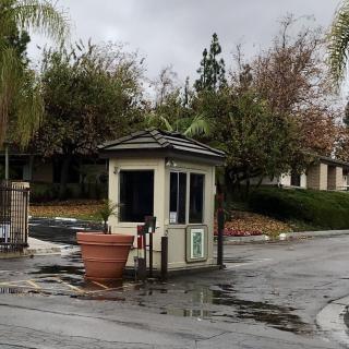 A small guard booth at the entrance of a gated community on a cloudy day.