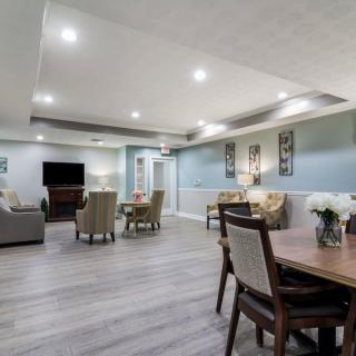 A modern living room with an open layout, featuring comfortable furniture, wood flooring, and decorative art.