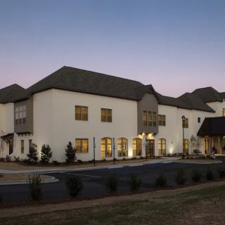 A modern building with exterior lighting at dusk.