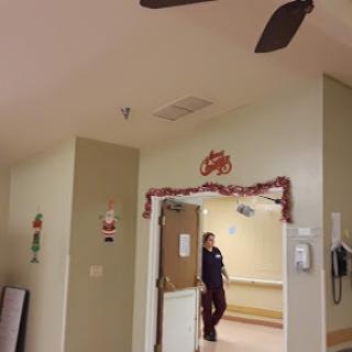 A view of an interior hallway with a doorway and ceiling fan.