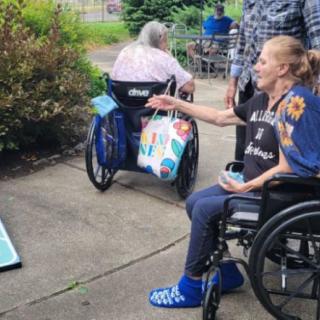 Elderly individuals in wheelchairs enjoying an outdoor game together.