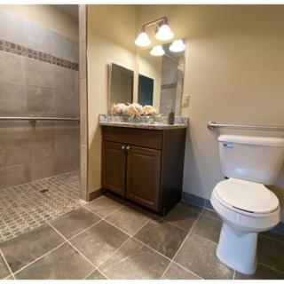 A modern bathroom with a tiled shower and vanity area.