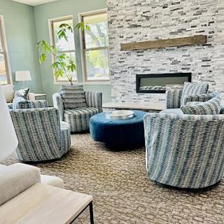 A cozy and modern living room featuring comfortable seating arranged around a stylish fireplace.