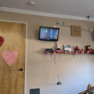 A cozy room featuring a television, decorated with heart-themed items and personal touches.