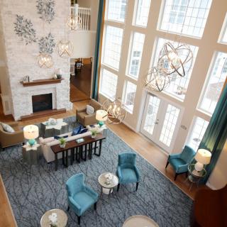 Spacious and elegantly designed living room with high ceilings and large windows.