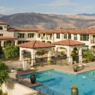 A scenic view of a resort with a swimming pool and mountainous backdrop.