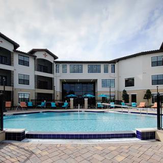 A modern apartment complex with an outdoor swimming pool.