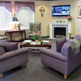 A cozy living room with two sofas, a fireplace, and a television.