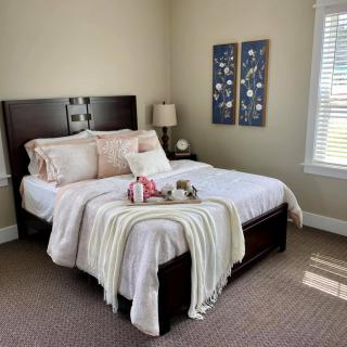 A cozy bedroom with a neatly made bed and elegant decor.