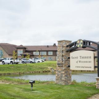 A view of the residential facility 'Saint Therese' with a welcoming sign and well-kept lawn.
