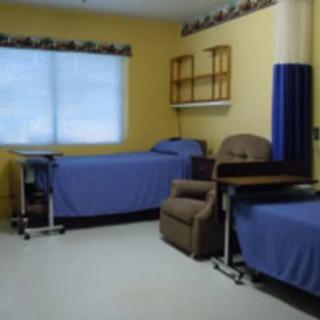 A hospital room with two beds and medical equipment.