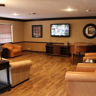 A cozy living room with comfortable seating and a TV on the wall.