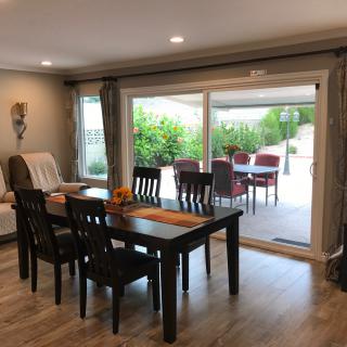 A modern dining area with a table and chairs, featuring a sliding door leading to an outdoor patio.