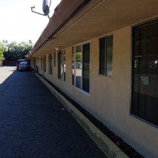 A view of the exterior of a motel featuring multiple windows and a parking area.