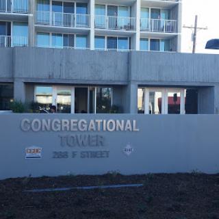 A view of Congregational Tower with a clear sign indicating its name.