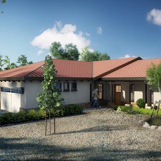 A beautifully designed single-story house surrounded by lush greenery and a gravel driveway.
