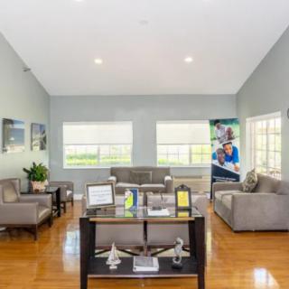 A modern living room with sleek furniture, large windows, and a hardwood floor.