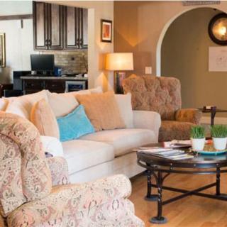 A cozy living room featuring a comfortable sofa, patterned armchairs, and a coffee table.
