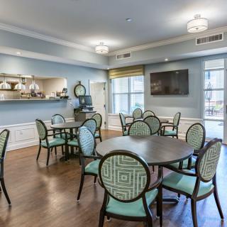 A cozy dining area with elegant tables and chairs, featuring soft lighting and a pleasant decor.