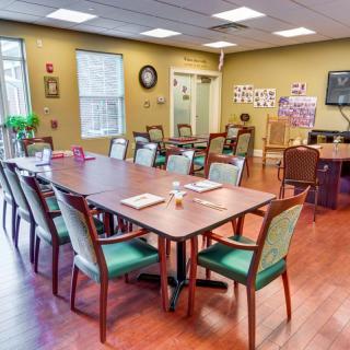 A well-lit conference room with arranged tables and chairs, ready for a meeting.