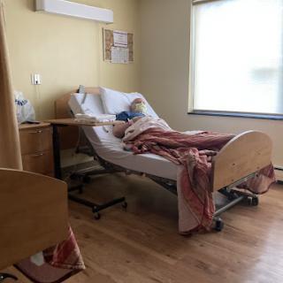 A patient resting in a hospital room, surrounded by medical equipment.
