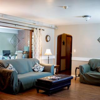 Cozy living room with a sofa, armchair, and warm lighting.
