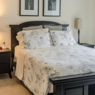 A cozy bedroom with a neatly made bed and elegant decor.