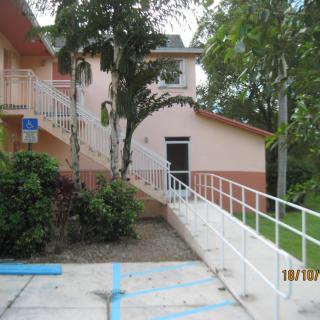 An outdoor ramp leading to a building entrance surrounded by trees.