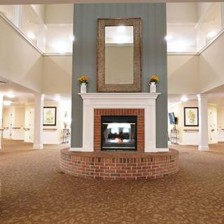 A spacious lobby with a central brick fireplace and modern decor.