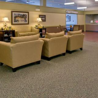 A comfortable waiting area with beige sofas and warm lighting.