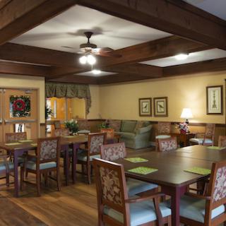 A cozy dining area featuring wooden beams, stylish furniture, and warm lighting.