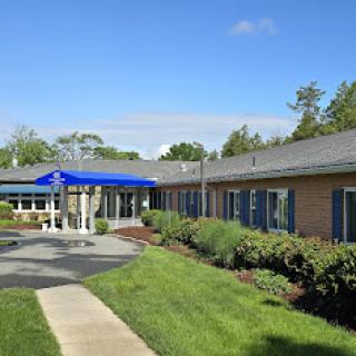 A well-maintained building with a welcoming entrance and green landscaping under a clear blue sky.