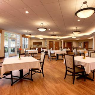 A spacious dining area with elegantly set tables and warm lighting.