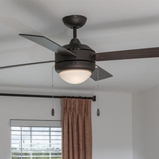 A modern ceiling fan with a built-in light fixture in a room setting.