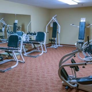 A gym with various exercise machines and equipment.