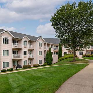 A scenic view of a residential apartment complex with a well-maintained landscape.