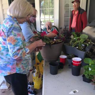 People gathered around a table engaged in gardening activities.