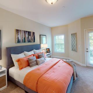 A modern bedroom with orange accents and stylish decor.