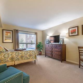 A cozy living room with stylish decor, featuring comfortable furniture and a large window.