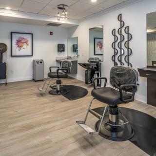 A modern hair salon with stylish chairs and mirrors, featuring a clean and contemporary design.