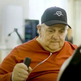 An elderly person exercising in a gym setting.