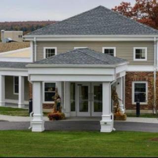 A modern architectural building with a welcoming entrance and landscaped surroundings.